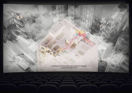 Architectural presentation in a dark theatre, showcasing innovative urban design concepts on screen.