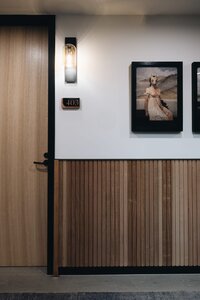 Modern hallway with wooden door, warm lighting, and artwork – St James Park Residences.