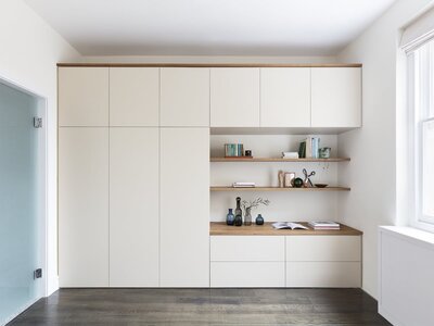 Modern minimalist study with sleek built-in storage and warm wood accents.