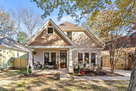 Inviting home exterior featuring a cozy porch, well-maintained garden, and charming architectural details.