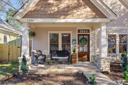 Charming house with inviting front porch, cozy seating area, and holiday decorations, showcasing quality craftsmanship.