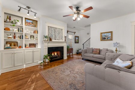 Living room with fireplace, bookshelves, and stylish furnishings for cozy home ambiance.