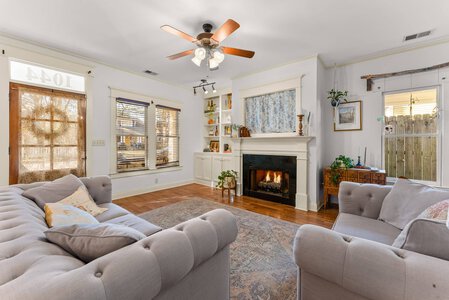 Bright living space featuring a warm fireplace and large windows for natural illumination.