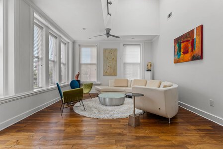Bright, spacious living room with contemporary design, colorful art, and natural light.