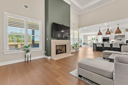 Bright living space featuring a fireplace, large windows with shutters, and contemporary furniture design.