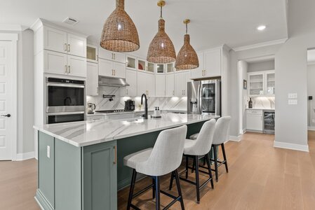 Elegant modern kitchen with white cabinets and marble countertops.