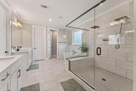 Bright bathroom with walk-in shower, soaking tub, and stylish black hardware for a luxurious feel.