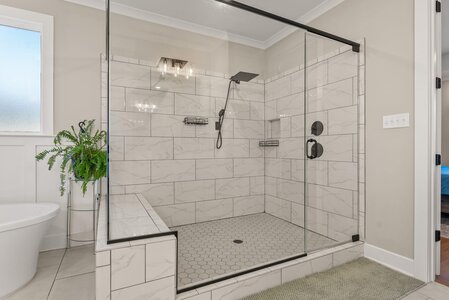 Elegant walk-in shower with glass enclosure and matte black hardware.