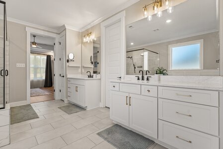 Bright, spacious bathroom with dual sinks, walk-in shower, and contemporary fixtures.