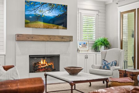 Modern living room featuring a fireplace, plush armchair, and wall-mounted TV for comfort and style.