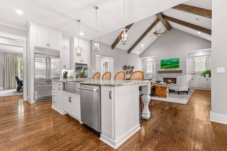 Bright kitchen with white cabinets, stainless steel appliances and wooden accents.