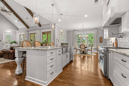 Bright white kitchen with spacious island, hardwood floors, and ample natural light.