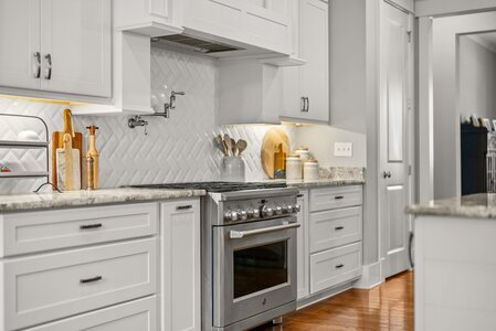 Bright kitchen featuring white cabinets and stainless steel appliances.