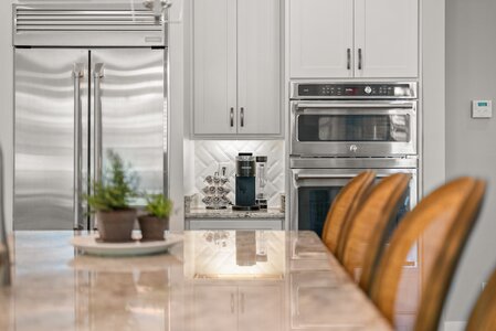High-quality kitchen image featuring stainless steel refrigerator and ovens with Keurig coffee station.