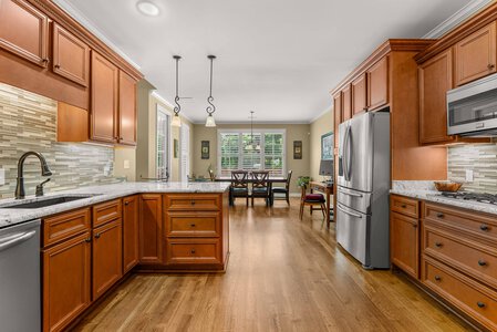 Bright kitchen with warm wood cabinetry and modern stainless steel appliances.