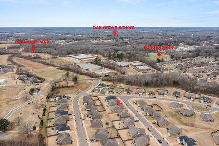 Bird's-eye view of a suburban neighborhood highlights nearby parks and schools, emphasizing community living and outdoor recreational options.