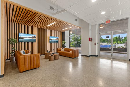 Bright reception area with leather sofas, wooden accents, and natural light at John Langevin clinic.