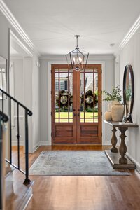 Bright, welcoming foyer with stylish chandelier and decorative vases.