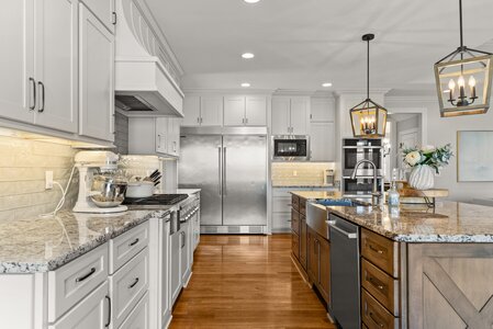 Bright kitchen with stainless steel appliances and elegant light fixtures.