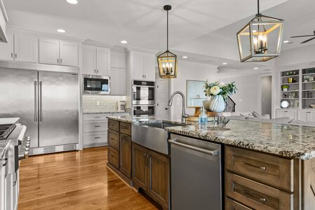 Bright, spacious kitchen featuring white cabinetry and a large island with granite counter.