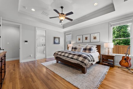 Bright bedroom featuring large windows and wooden furniture.