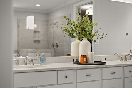 Luxurious bathroom decor featuring modern vases, candles, and lush greenery for home elegance.