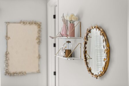 Decorative wall with flower vase, plush toy, and mirror, perfect for enhancing interior style.
