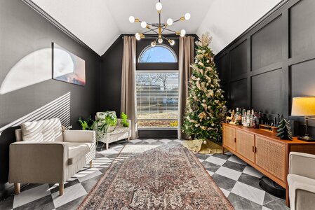 Bright and cozy holiday living room with Christmas tree, elegant furniture, and natural sunlight.