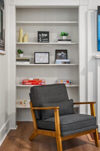 Stylish grey armchair with wooden frame in a cozy living space.
