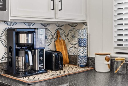 High-quality coffee brewing setup on a stylish kitchen counter with patterned tiles.