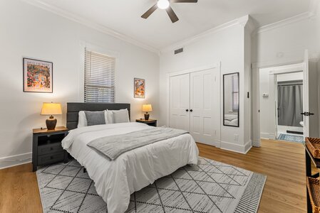 Bright and inviting bedroom featuring minimalist decor, white bedding, and natural light, perfect for relaxation.
