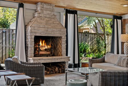 Elegant indoor patio featuring a stone fireplace and comfortable seating area for relaxing or entertaining.