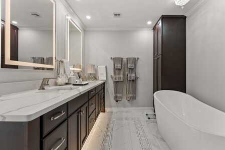 Luxury bathroom featuring a spacious double vanity, elegant mirror, and a modern bathtub. Perfect for a sophisticated home retreat.