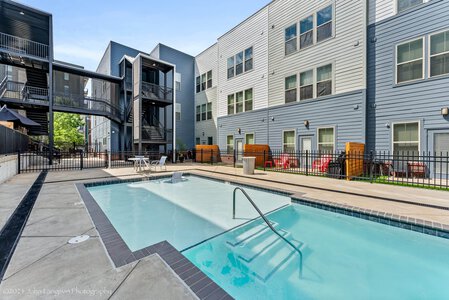 Charming apartment community with swimming pool, lounge chairs, and outdoor amenities.