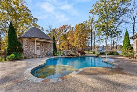 Beautiful outdoor pool with waterfall feature and surrounding nature scenery.
