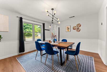 Elegant dining space featuring blue velvet chairs and a contemporary wooden table setup.