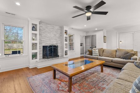Cozy living room featuring a white brick fireplace, neutral-toned furniture, and stylish decor accents.