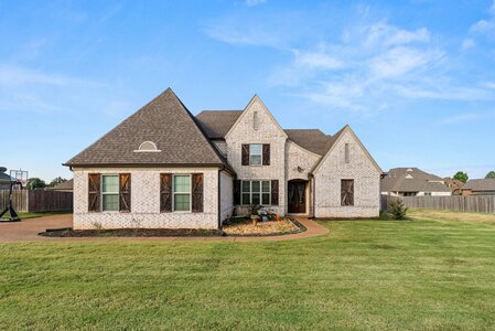 Stunning brick residence, well-maintained lawn, and beautiful backyard space.