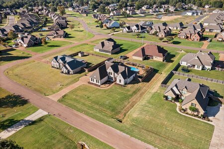 Aerial view of family-friendly residential neighborhood with spacious yards and well-maintained houses.