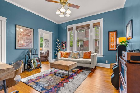 Bright living room featuring blue walls, large windows, and musical guitar collection.