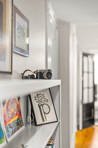 High-quality camera placed on a white shelf showcasing artistic photography and creative content.