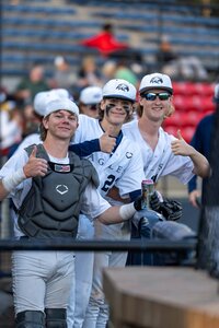 All-American baseball players celebrating victory, smiling and cheering in uniform after game.