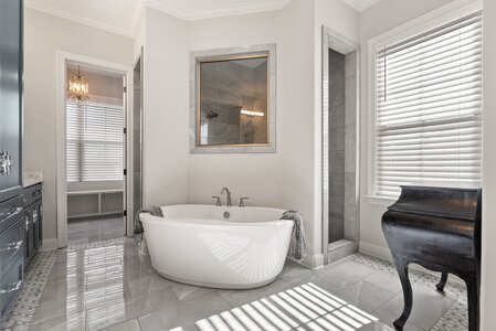 Elegant bathroom featuring a freestanding bathtub, shower, and stylish decor by John Langevin.