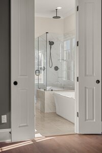 Bright bathroom with glass shower enclosure and elegant marble tiles.