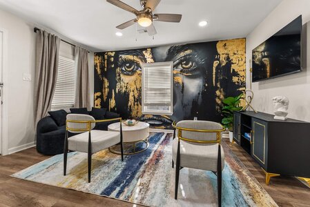 Stylish living room with contemporary furniture, colorful rug, and accent art pieces.