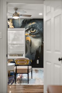 Contemporary home decor featuring artistic wall mural, stylish chairs, and cozy ambiance.