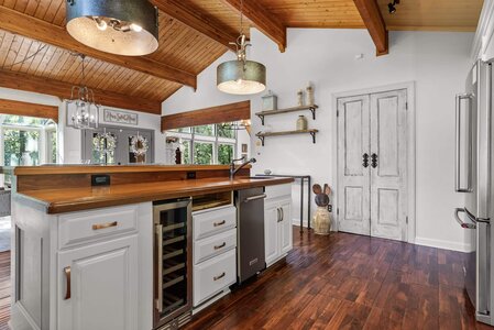 Spacious kitchen featuring wooden ceiling, white cabinets, and stainless steel appliances.