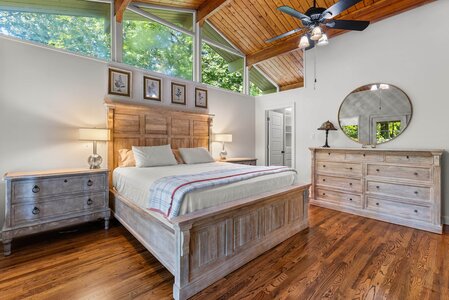 Bright bedroom with natural sunlight, wooden furniture, and modern decor for a serene stay.