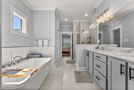 Luxurious bathroom featuring a soaking tub, elegant vanity with marble countertops, and steam shower for relaxation.