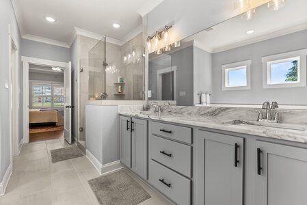 Bright, spacious bathroom featuring double sinks, stylish fixtures, and natural light.